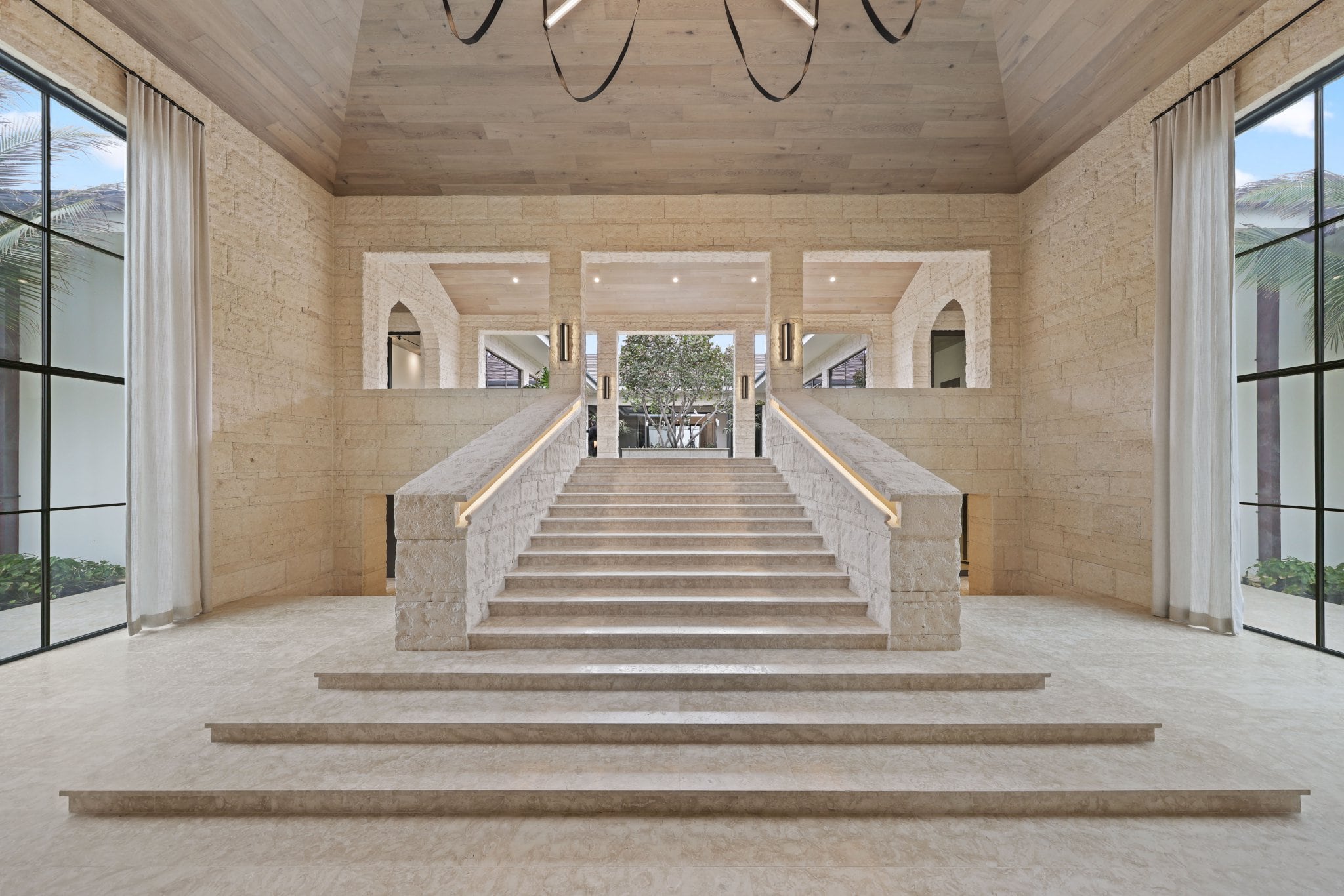 Double stair hall in cut travertine